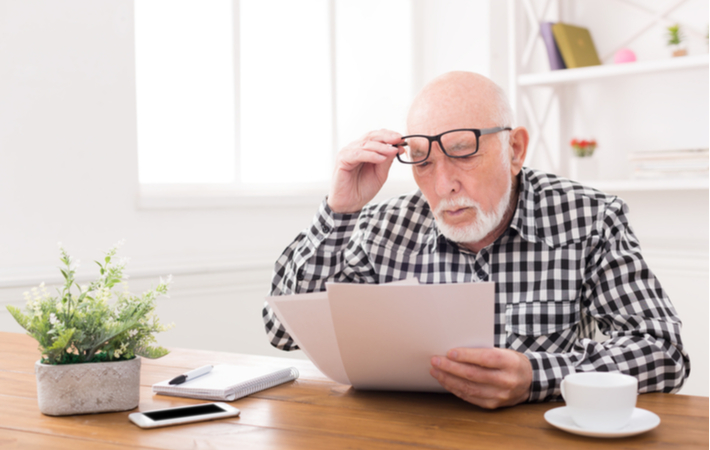 man struggling to read text from presbyopia